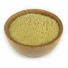 Bowl of green herb powder like papaya seed powder for health benefits and nutrition