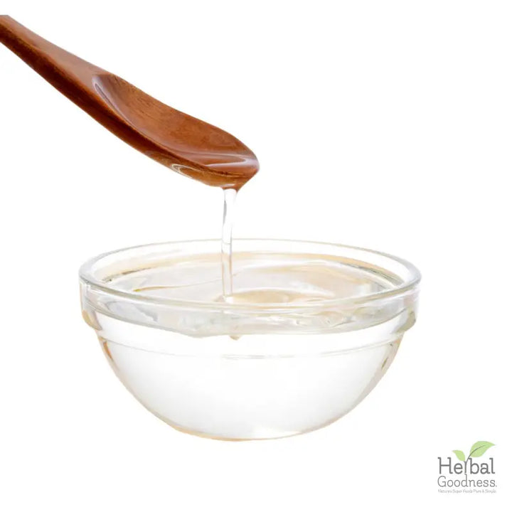 Wooden spoon dripping honey into a bowl highlighting SuperGreen Powders for immune support