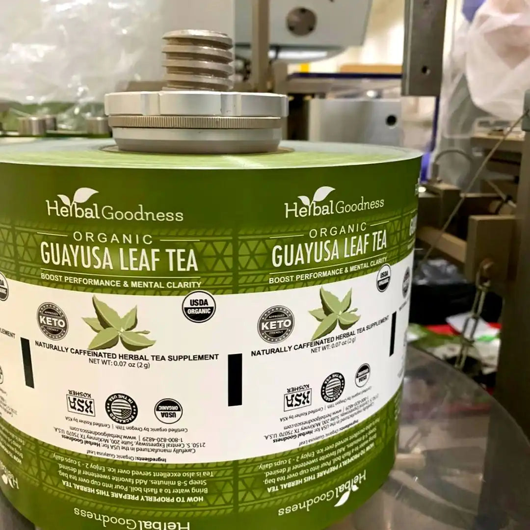 Roll of green and white product labels for Organic Guayusa Leaf Tea by Herbal Goodness.